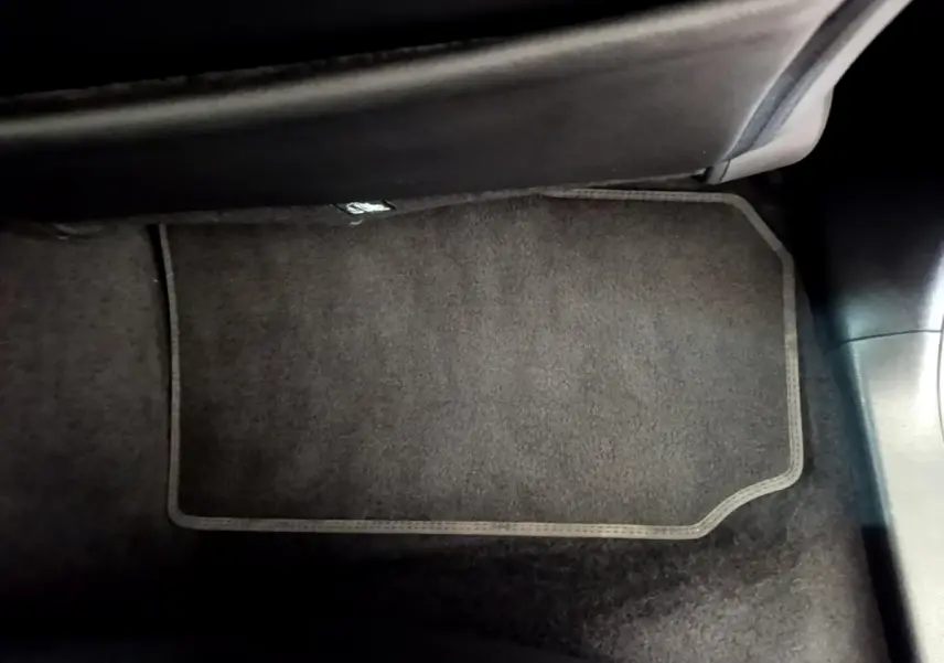 Tapis de sol noir côté passager avant dans l'habitacle d'une Nissan Leaf blanche 2020.
