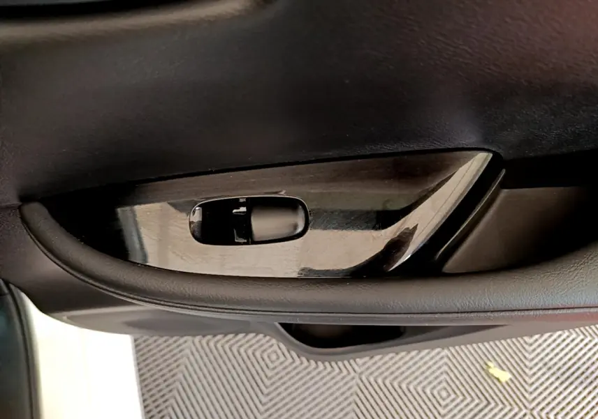 Poignée intérieure côté gauche en plastique noir brillant dans une Nissan LEAF 62 kWh Business+ blanche de 2020.