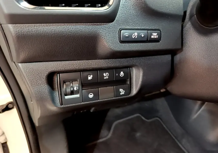 Gros plan sur les commandes noires du tableau de bord côté conducteur d'une Nissan Leaf blanche 2020.