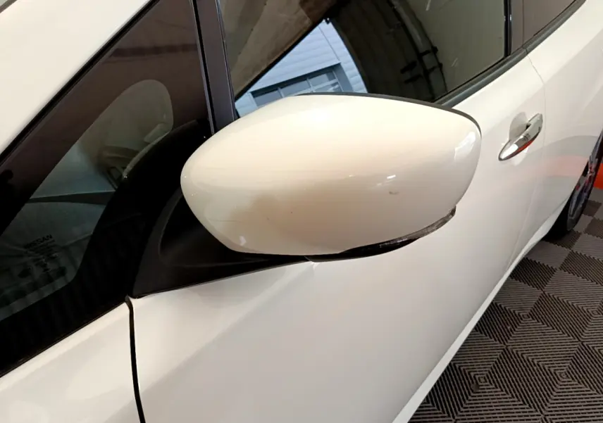 Rétroviseur côté gauche blanc sur Nissan Leaf 62 kWh 2020 avec poignée de porte chromée visible.