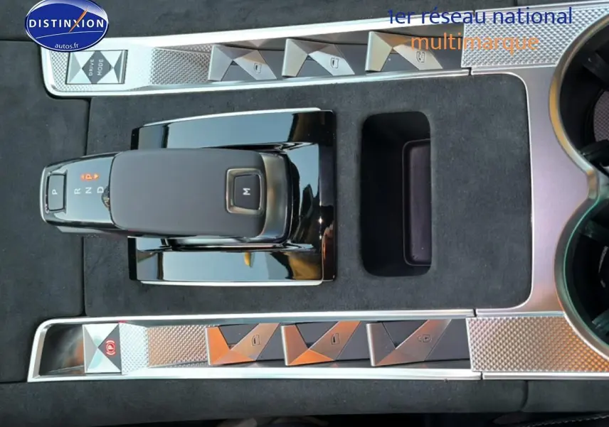 Vue plongeante sur la console centrale noire du DS7 1.5 BlueHDi 130 avec levier de vitesses automatique et boutons chromés.