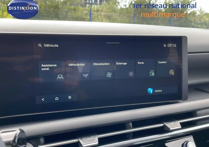 Écran tactile central du tableau de bord du Hyundai Tucson blanc, affichant les réglages du véhicule en intérieur.