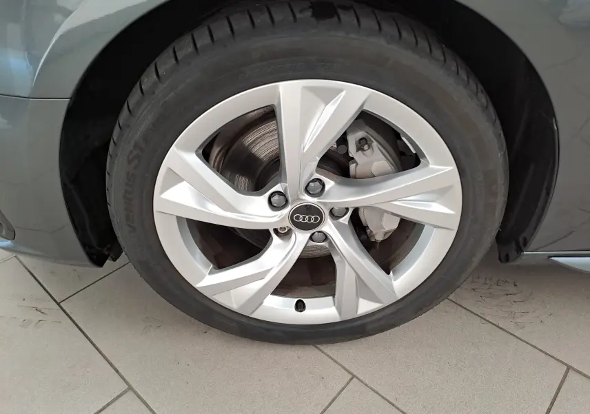 Gros plan sur la roue avant gauche de l'Audi A4 Avant 40 TDI gris Daytona avec jante argentée à cinq branches.