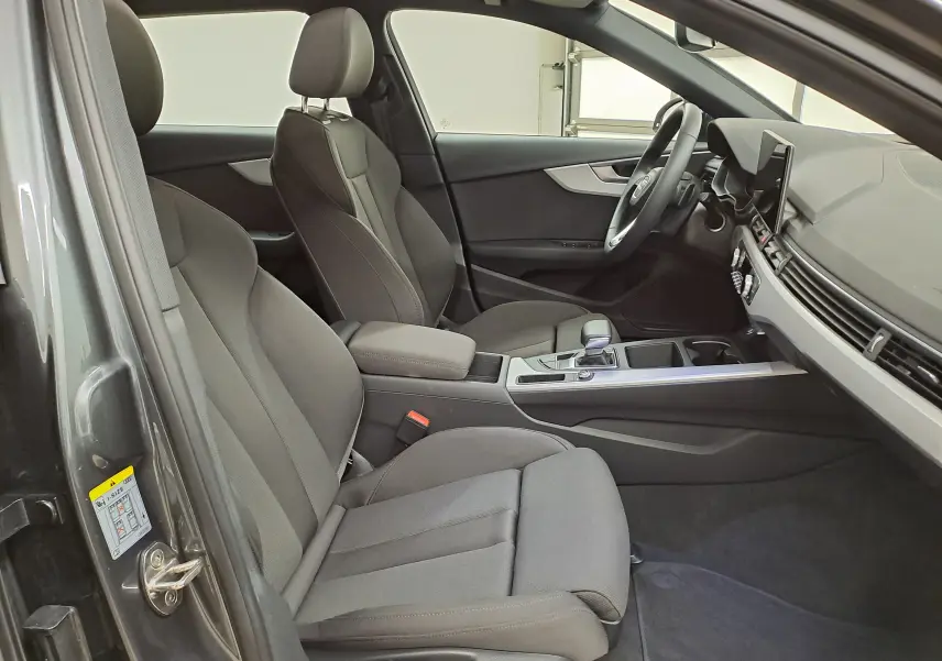 Intérieur avant droit de l'Audi A4 Avant 40 TDI gris Daytona, sièges tissu gris et tableau de bord moderne.