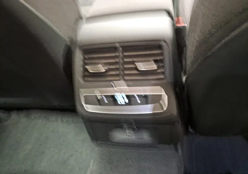 Vue rapprochée des commandes de ventilation arrière et chargeur USB dans l’Audi A4 Avant 40 TDI gris Daytona 2024.