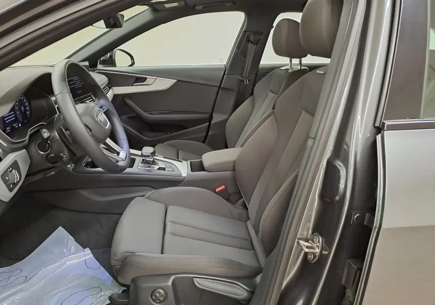 Intérieur avant droit d'une Audi A4 Avant 40 TDI 2024 gris Daytona, sièges tissu noirs et tableau de bord moderne.