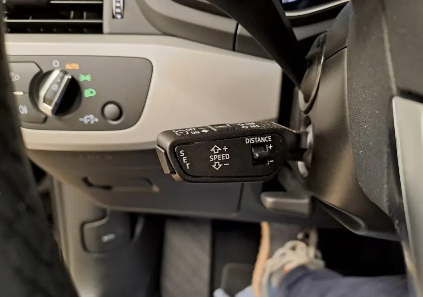 Gros plan sur la commande du régulateur de vitesse adaptatif à gauche du volant dans l'Audi A4 Avant 2024.