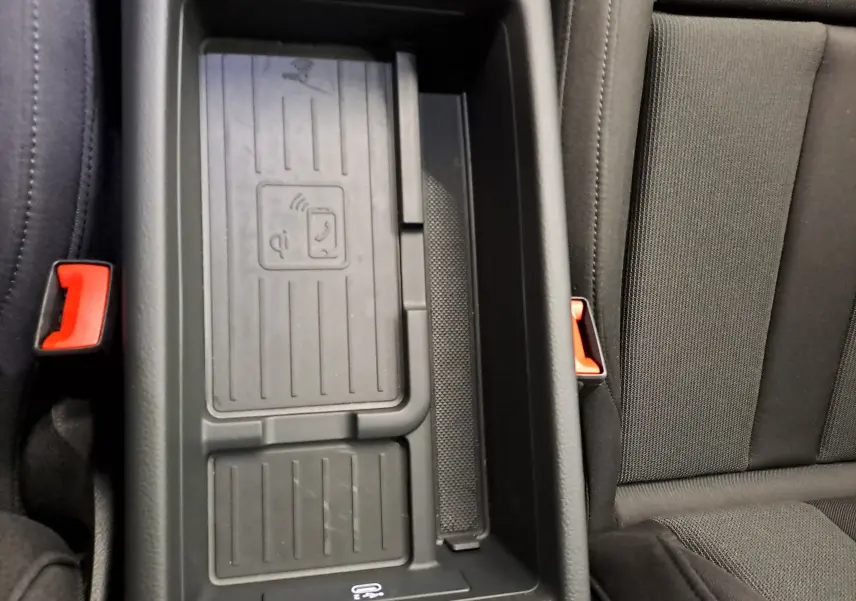 Gros plan sur le chargeur sans fil et la console centrale noire de l'Audi A4 Avant 40 TDI 2024.