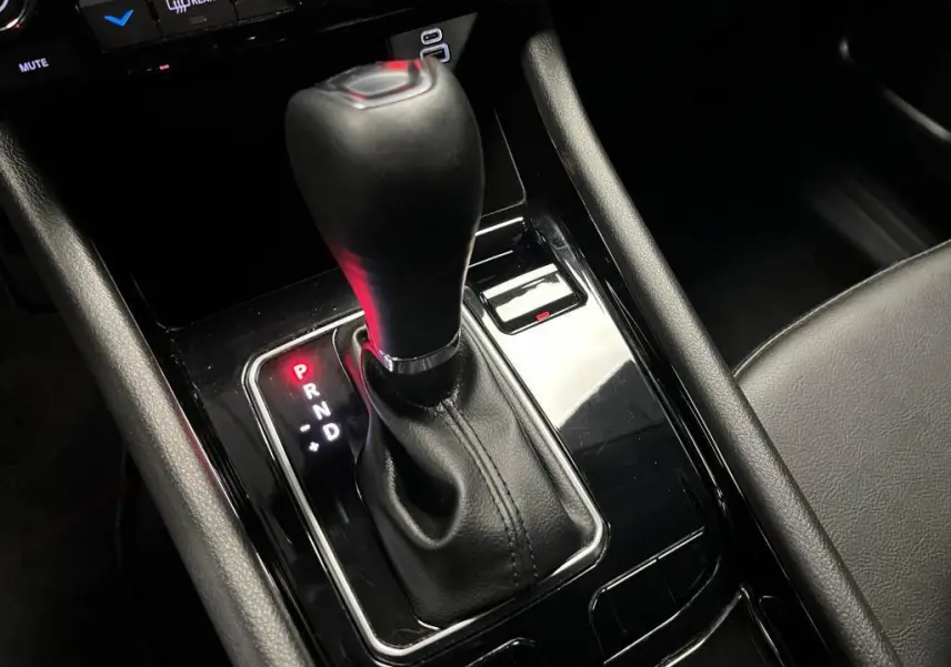 Le levier de vitesse automatique noir du Jeep Compass 2024 e-Hybride, entouré de garnitures brillantes dans l'habitacle.