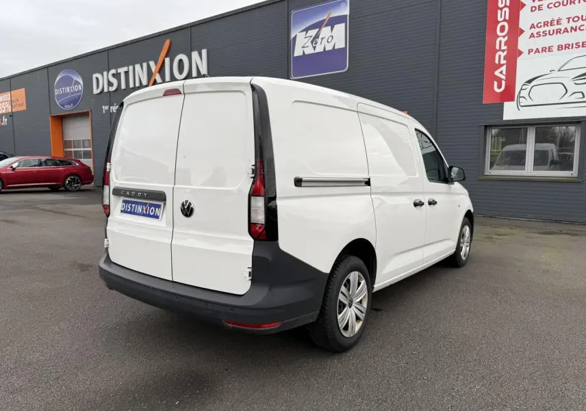 Vue 3/4 arrière droite d'un Volkswagen Caddy Maxi Cargo blanc Candy avec portes arrière battantes et pare-chocs noir.