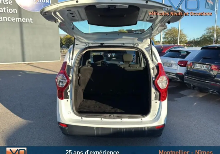 Vue arrière ouverte d'un Dacia Lodgy blanc 2018, coffre spacieux et sièges arrière visibles en extérieur.