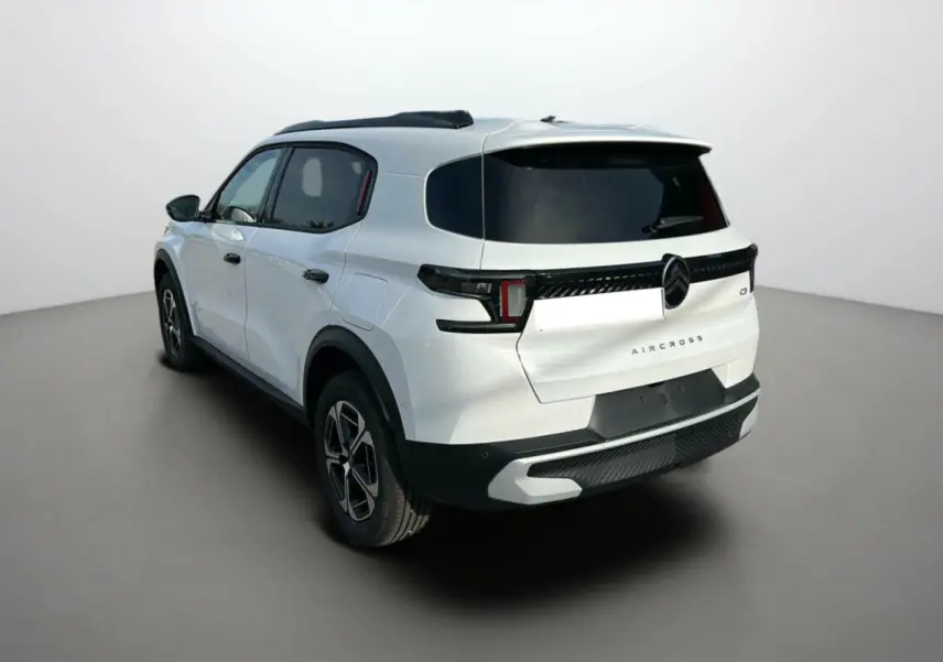 Vue 3/4 arrière droite d'un Citroën C3 Aircross blanc banquise avec vitres surteintées et jantes alu 17 pouces.