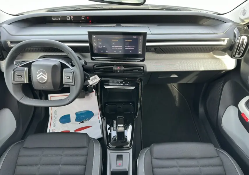 Intérieur moderne du Citroën C3 Aircross blanc banquise, vue frontale sur le tableau de bord et volant multifonctions cuir.