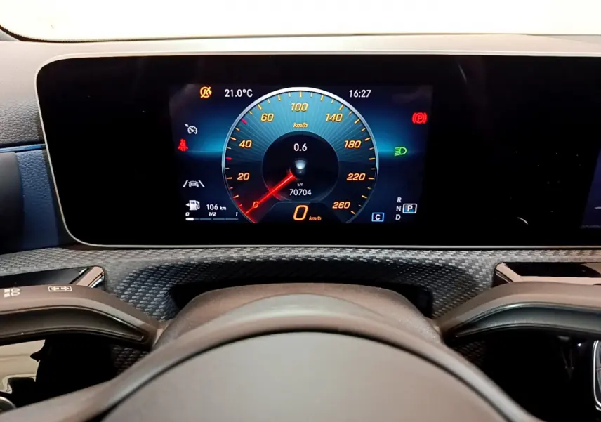 Vue rapprochée du tableau de bord numérique de la Mercedes Classe A 180 d gris clair, affichant la vitesse et les alertes.