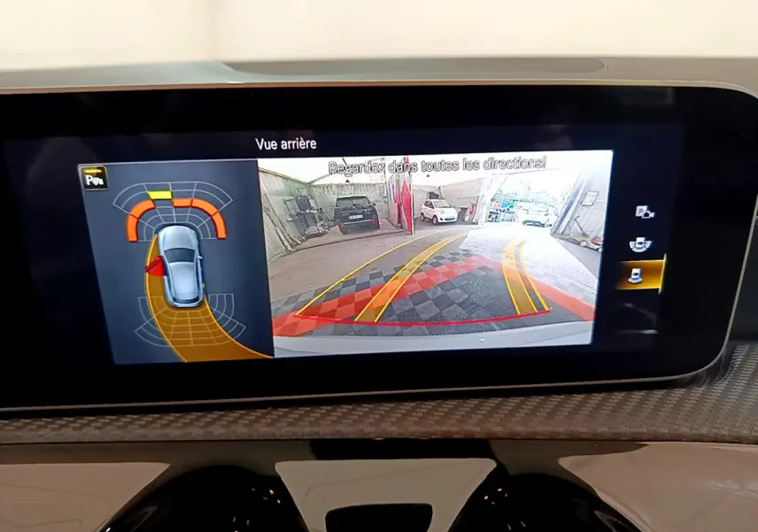 Écran tactile intérieur montrant la caméra de recul et l'aide au stationnement de la Mercedes Classe A gris clair.