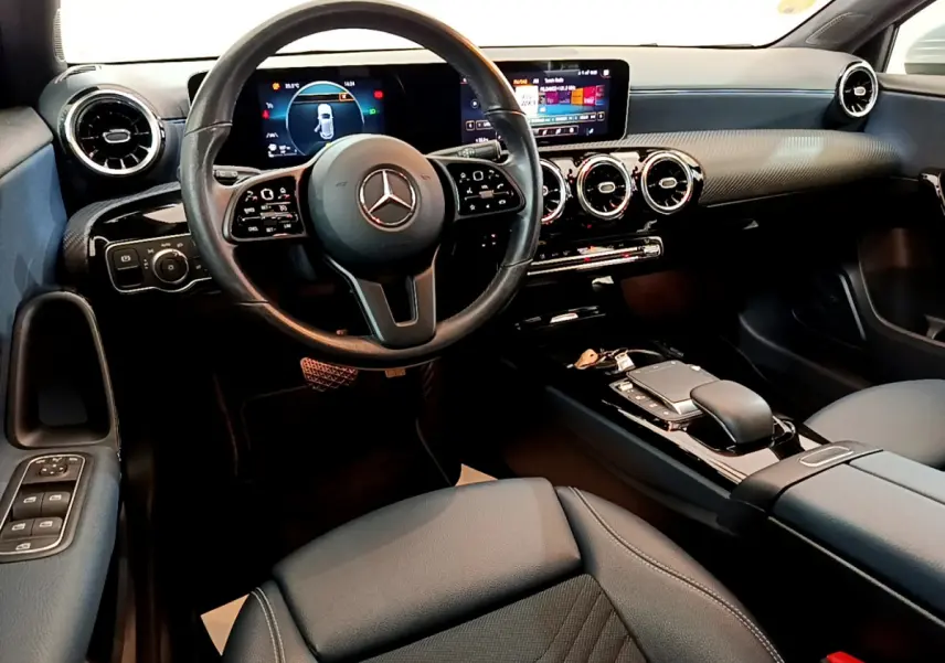 Intérieur moderne de la Mercedes Classe A 180 d Business Line 2020, vue cockpit côté conducteur avec écran tactile et volant cuir.