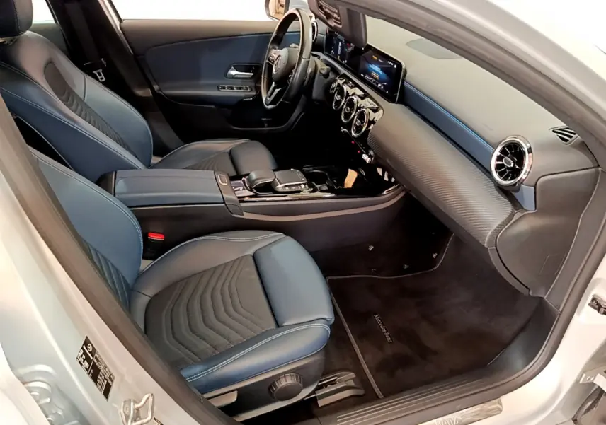 Vue intérieure côté conducteur de la Mercedes Classe A 180 d Business Line 2020 avec sièges bleu foncé et tableau de bord moderne.