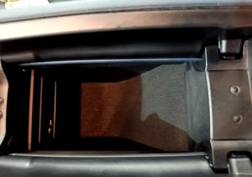 Vue rapprochée de la console centrale ouverte d'une Mercedes Classe A 180 d Business Line gris clair, montrant un espace de rangement intérieur.