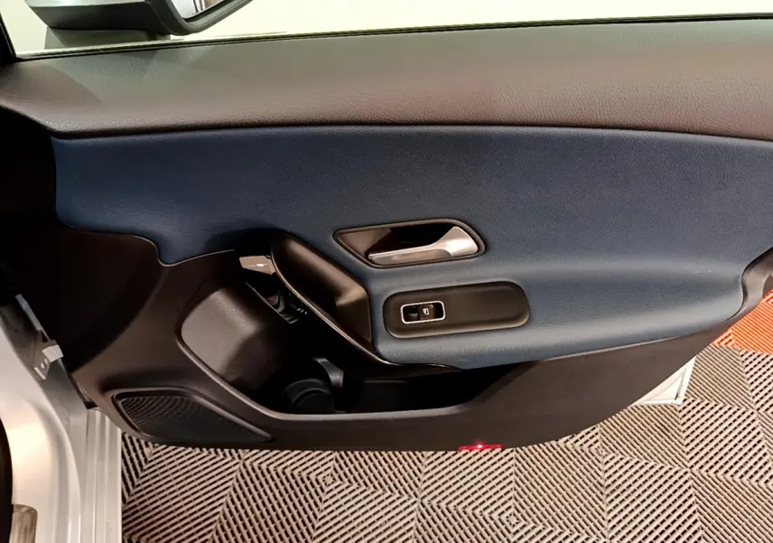 Vue rapprochée de la porte intérieure côté gauche d'une Mercedes Classe A 180 d Business Line 2020 avec garniture bleu foncé.