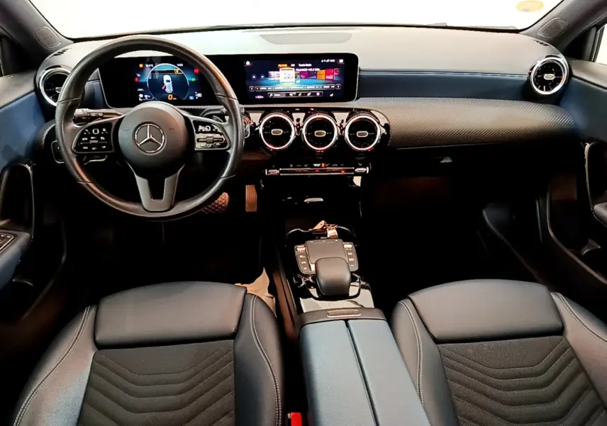 Intérieur noir de la Mercedes Classe A 180 d Business Line 2020, vue frontale sur le tableau de bord et le volant cuir multifonctions.