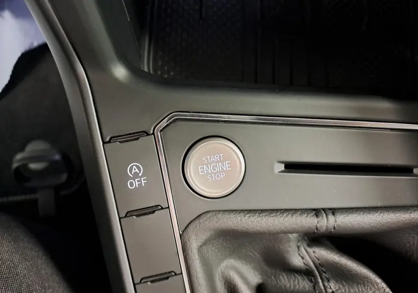 Gros plan sur le bouton Start Engine Stop et la commande Auto Start-Stop désactivée, intérieur noir cuir du Volkswagen Taigo.