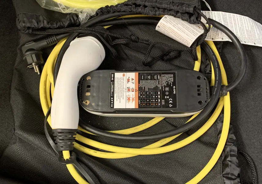 Câble de recharge jaune et prise blanche pour SEAT LEON E-HYBRID 204 FR DSG6, vue rapprochée sur le chargeur.