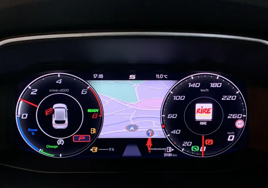 Tableau de bord numérique de la SEAT LEON E-HYBRID gris, affichant la carte GPS et compte-tours à 17h18.