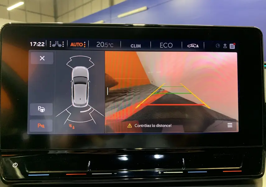 Écran multimédia de la SEAT LEON E-HYBRID 204 FR DSG6 montrant la caméra de recul avec guidage de trajectoire et alertes de distance.
