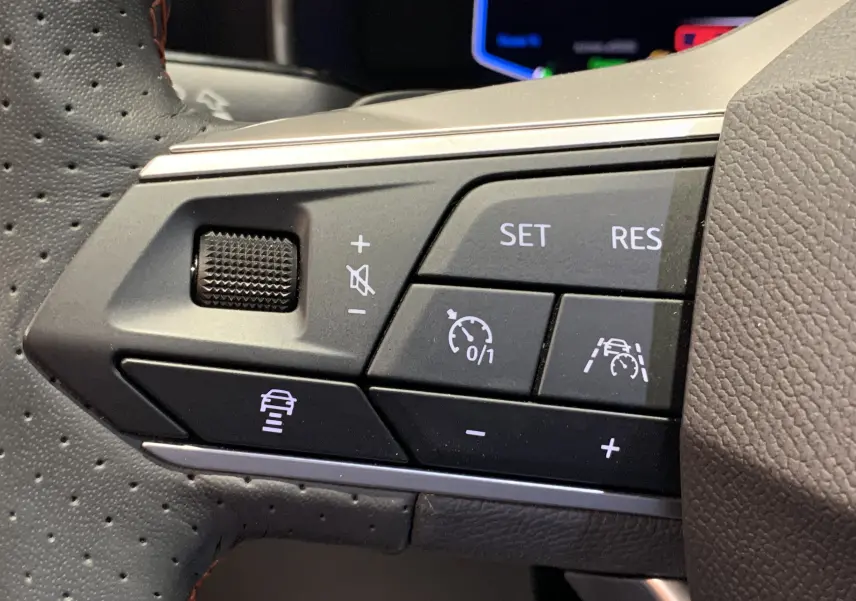 Gros plan sur les commandes de régulateur de vitesse au volant en cuir perforé gris d'une SEAT Leon E-HYBRID 2020.
