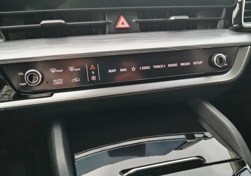 Détail de la console centrale du Kia Sportage gris perle 2025, avec commandes tactiles et bouton volume.
