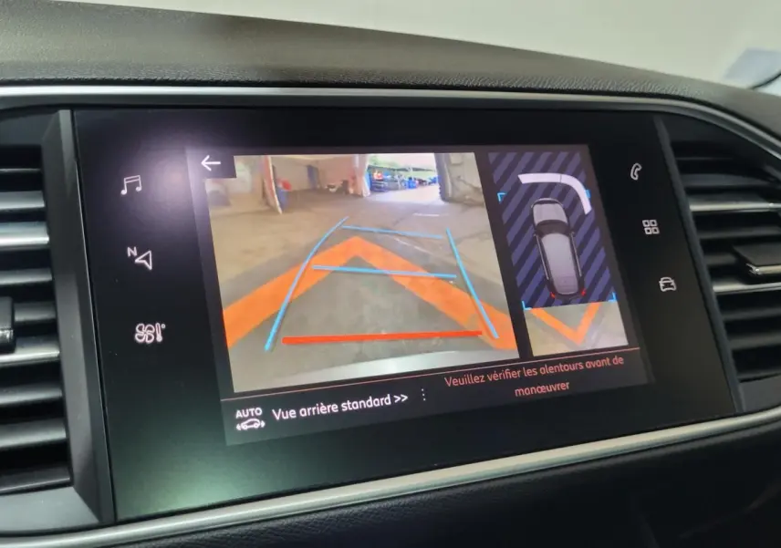Écran tactile central affichant la caméra de recul et l'aide au stationnement sur Peugeot 308 gris foncé.