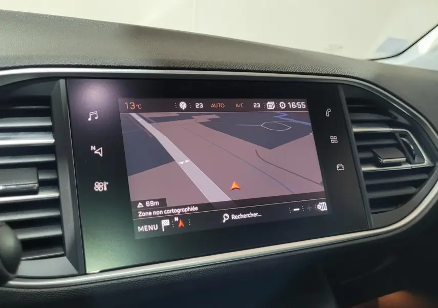 Écran tactile central du tableau de bord d'une Peugeot 308 gris foncé, affichant la navigation GPS.