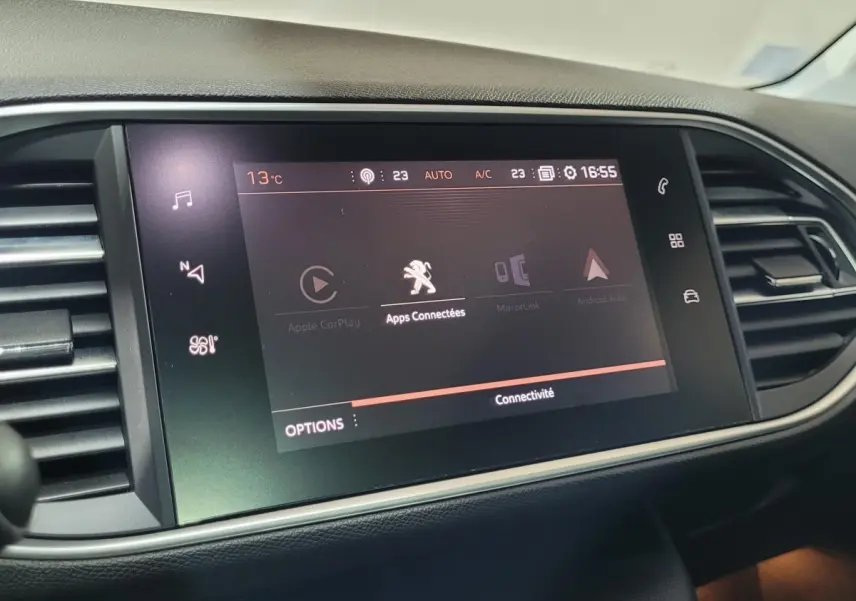Écran tactile central affichant les applications connectées dans l’habitacle d’une Peugeot 308 gris foncé de 2020.