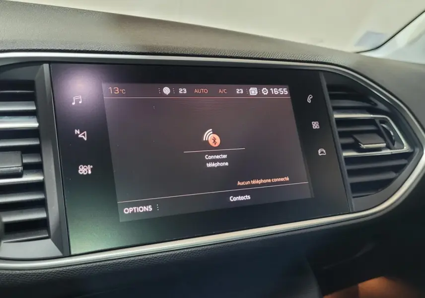 Écran tactile central affichant la connexion Bluetooth dans l'habitacle noir d'une Peugeot 308 gris foncé, vue de face.