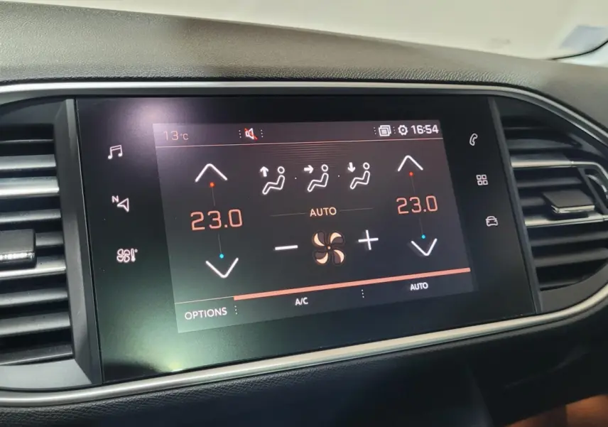 Écran tactile central affichant la climatisation bi-zone à 23°C dans le tableau de bord d'une Peugeot 308 gris foncé.