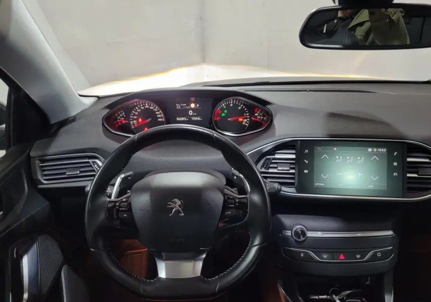 Vue intérieure centrée sur le volant cuir et tableau de bord avec écran tactile de la Peugeot 308 gris foncé de 2020.