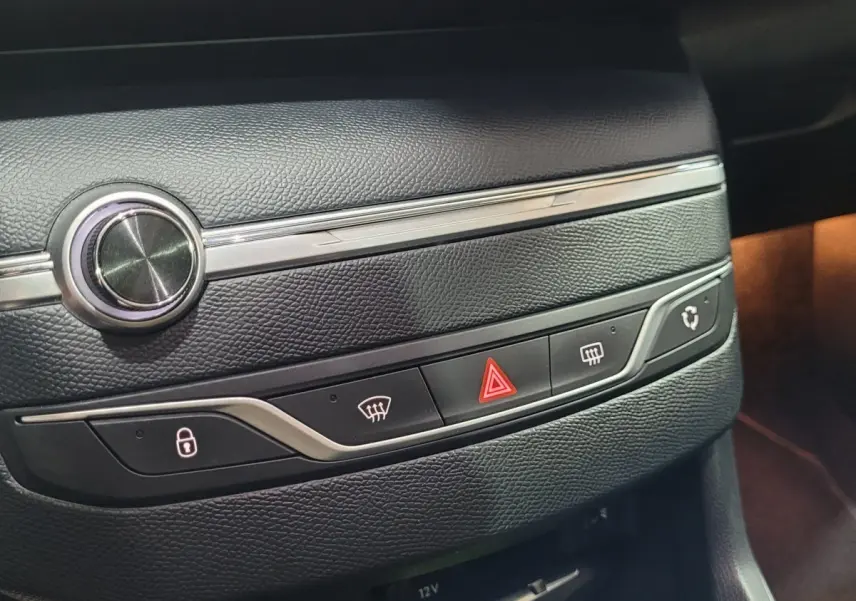Gros plan sur la console centrale en cuir noir de la Peugeot 308 gris foncé, avec boutons de verrouillage et warning.