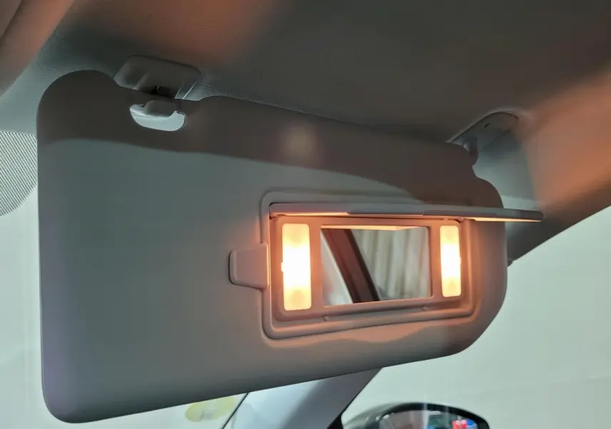 Miroir de courtoisie éclairé sur pare-soleil côté conducteur dans l'habitacle d'une Peugeot 308 gris foncé 2020.