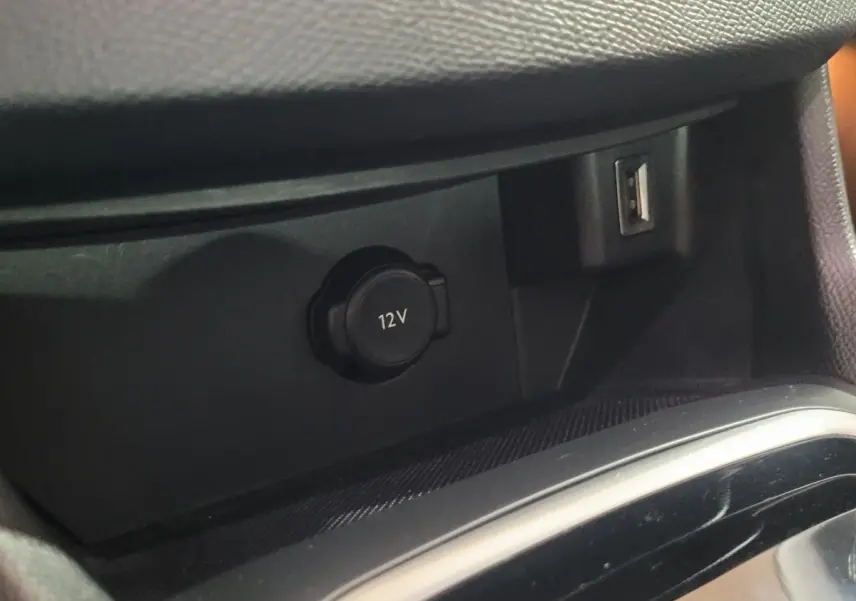 Prise 12V et port USB en gros plan dans l'habitacle noir de la Peugeot 308 BlueHDi 130 EAT8 Allure Business 2020