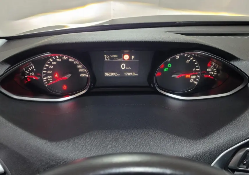 Tableau de bord de Peugeot 308 2020 avec compteurs numériques et voyants allumés, vue depuis le volant.