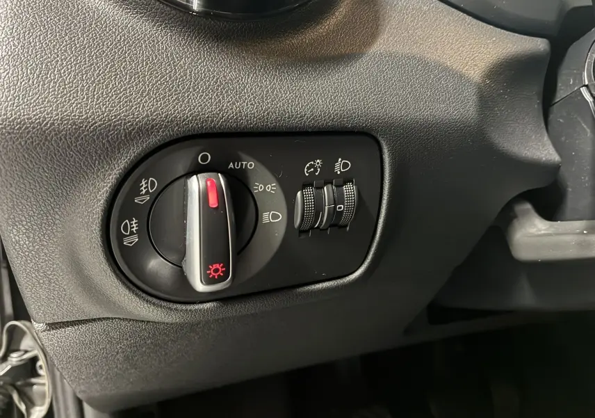 Gros plan sur le bouton de commande des phares et réglages d’éclairage intérieur noir dans l’Audi A1 2016 S-Line.