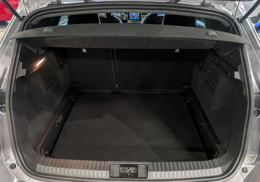 Coffre ouvert vu de l’arrière d’une Renault Symbioz gris Cassiopé, montrant un espace de chargement propre et spacieux.