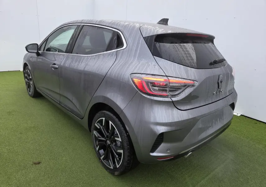 Vue 3/4 arrière droite d'une Renault Clio gris schiste métallisé avec jantes alliage noires et vitres surteintées.