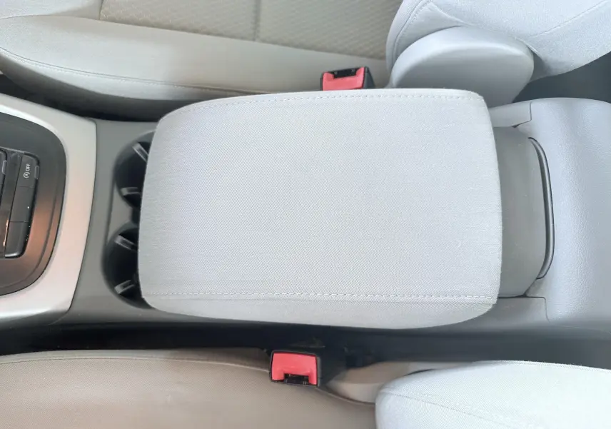 Gros plan sur l'accoudoir central gris clair et les ceintures de sécurité rouges de l'Audi Q5 2014 noir.