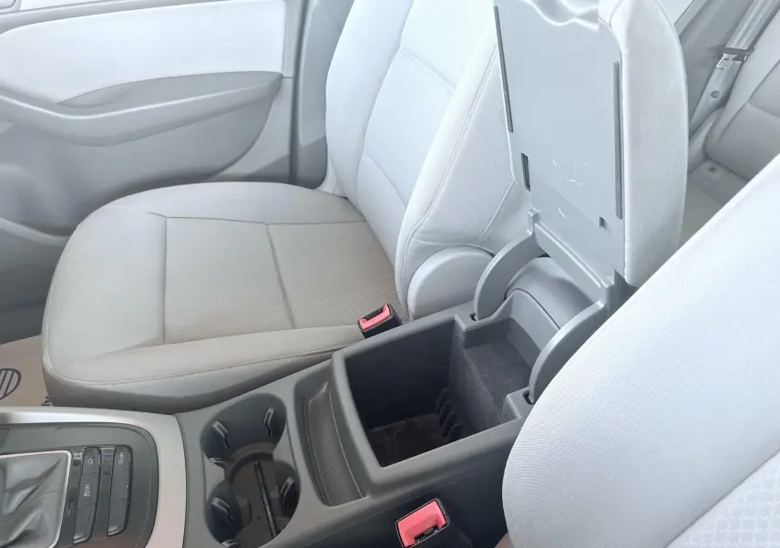 Vue intérieure centrée sur la console centrale ouverte et les sièges avant gris clair d’un Audi Q5 noir de 2014.