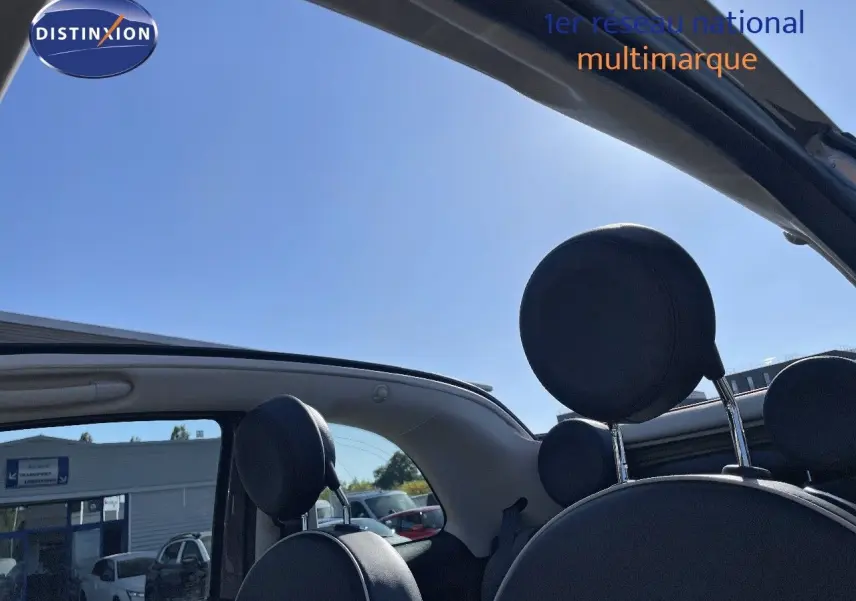 Vue intérieure arrière de la FIAT 500C grise électroclash, toit ouvert et appuie-têtes noirs visibles.