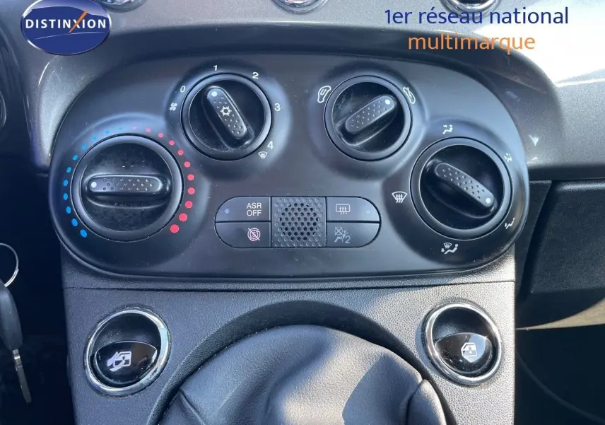 Détail du tableau de bord de la Fiat 500C 2019 montrant les commandes de climatisation et les boutons de lève-vitres.
