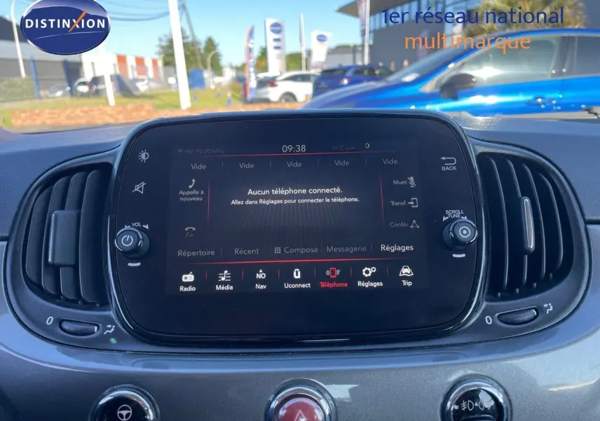 Vue intérieure centrée sur l'écran tactile multimédia de la Fiat 500C gris métallisé, avec commandes et aérateurs visibles.