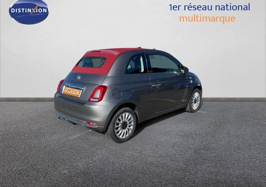 Fiat 500C grise électroclash vue 3/4 arrière côté droit avec toit rouge cabriolet fermé sur parking.