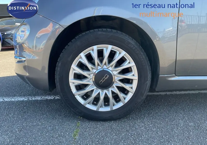 Gros plan sur la roue avant gauche d'une Fiat 500C grise électroclash avec jante alu multibranches.